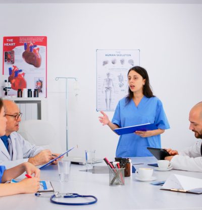 Attentive medical team discussing medicine problems, doctors with tablet pc and clipboards working in meeting hospital office. Brainstorming ideas, physicians diagnosis using modern technology