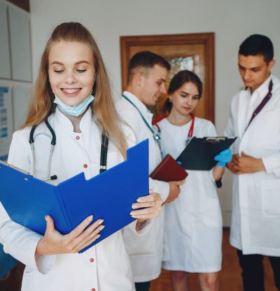 Men and women in hospital gowns study. Students practice medicine. Nurse with a stethoscope.